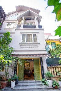 a white house with green doors and stairs at Chez Van in Hanoi