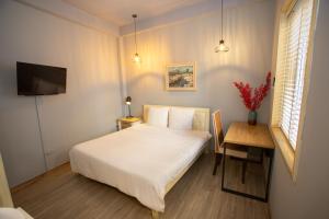 sypialnia z łóżkiem, biurkiem i telewizorem w obiekcie Chez Van w mieście Hanoi