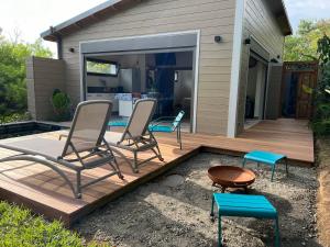 a deck with two chairs and a table and a bench at La Villa Paille en Queue in Saint-Gilles les Bains