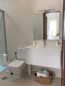 ein Badezimmer mit einem WC, einem Waschbecken und einem Spiegel in der Unterkunft Casa Ma in Guatiza