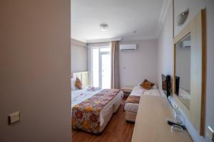 a hotel room with two beds and a mirror at Lara Dinc Hotel in Antalya