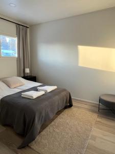 een slaapkamer met een bed met twee handdoeken erop bij Moderni paritalo lähellä lentokenttää, free parking, sauna in Vantaa