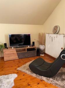 ein Wohnzimmer mit einem Flachbild-TV und einem Stuhl in der Unterkunft Haus Edeltraut in Bad Mitterndorf