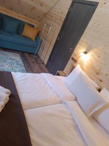 a large bed in a room with a blue couch at M&M House Kazbegi in Kazbegi