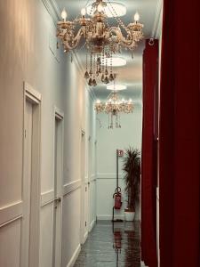 ローマにあるRosa Italia Hotel Romaのシャンデリアのある廊下