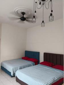 two beds sitting next to each other in a room at Homestay Othman Perlis-14pax-AC-Wifi-Kangar-BBQ in Kangar