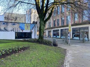 a tree in front of a building with a face on it at Queens Hotel Blackburn in Blackburn