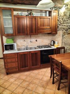 佛羅倫斯的住宿－Florentine style apartment in San Frediano，厨房配有木制橱柜、水槽和桌子