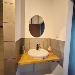 La salle de bains est pourvue d'un lavabo et d'un miroir. dans l'établissement GuestHouse Maison Standard, à Kula