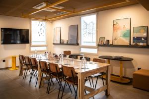 a room with a long table with chairs and windows at JOST Auberge de jeunesse Le Havre Centre Gare in Le Havre