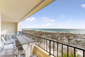 a balcony with a table and chairs and a view of the beach at Surf Dweller 211 in Fort Walton Beach