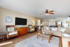 a living room with a couch and a flat screen tv at Surf Dweller 211 in Fort Walton Beach
