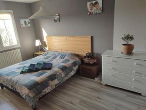 a bedroom with a bed with a wooden headboard and a dresser at Près de St Étienne et du Parc Naturel Régional du Pilat in Saint-Just-Malmont