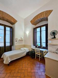 um quarto com uma cama, uma mesa e janelas em Confortevole App Centro Storico em Florença
