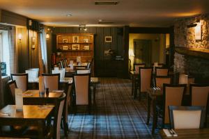 a restaurant with tables and chairs in a room at The Heathfield Inn in Honiton