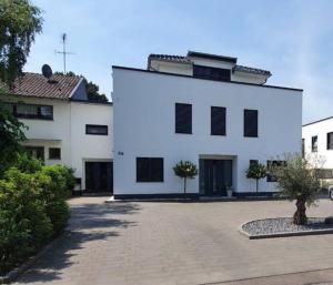 a white building with black windows and a courtyard at Haus mit viel Platz, Terrasse und Garten in Alfter