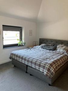 a bedroom with a bed with a plaid blanket and a window at Haus mit viel Platz, Terrasse und Garten in Alfter
