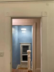 - une porte menant à une chambre avec une fenêtre et un miroir dans l'établissement Belle Isle Cottage - 1905 Historic Home near city, à Detroit
