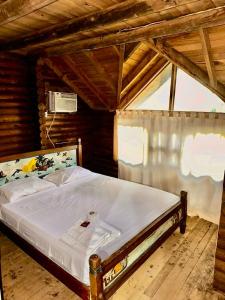 1 dormitorio con 1 cama en una habitación de madera en Mistica Island Hostel - Isla Palma, en Isla Palma