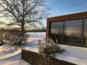 une maison avec de la neige au sol à côté d'un bâtiment dans l'établissement L'annexe, à Stavelot