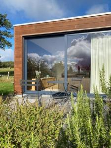 une maison dotée d'une grande fenêtre avec une table et des chaises dans l'établissement L'annexe, à Stavelot