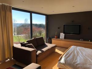 a living room with a couch and a flat screen tv at L'annexe in Stavelot