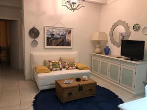 ein Wohnzimmer mit einem Sofa und einem TV in der Unterkunft Le Muse casa vacanze in Scoglitti