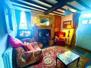 a living room with a couch and a fireplace at Castle Buildings Cottage1 in Llanrhaeadr-ym-Mochnant