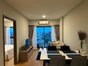 una sala de estar con mesa y una habitación con vistas. en Astra Sky River Chiang Mai en Chiang Mai