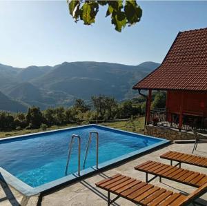 a swimming pool with two chairs and a gazebo at Dobar Pogled 2 in Kamenjača