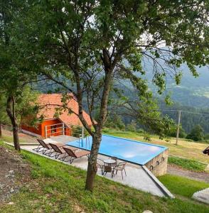 a swimming pool with tables and chairs next to a house at Dobar Pogled 2 