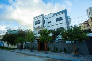 un edificio blanco con árboles delante de él en ABM house, en Tánger