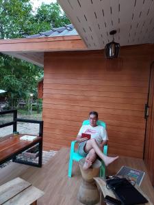 a man sitting in a chair on a patio at T&P at Pai in Pai