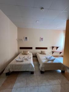 una habitación de hospital con dos camas. en GRAND SUN'S HOUSE en Puerto Baquerizo Moreno
