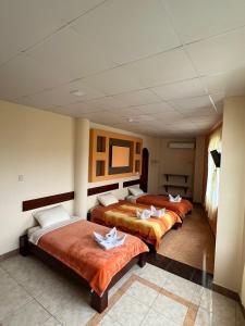 una fila de tres camas en una habitación en GRAND SUN'S HOUSE, en Puerto Baquerizo Moreno