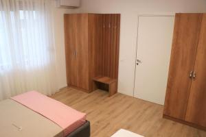 1 dormitorio con cama, armario y puerta en Albora Guest House, en Fier