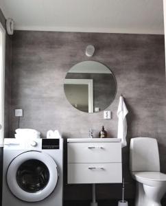 uma casa de banho com uma máquina de lavar roupa e um espelho. em Åsbergbo Vandrarhem em Vallsta