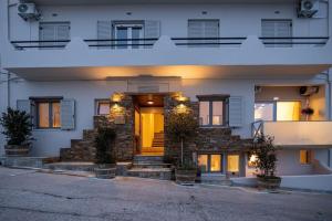 un edificio blanco con una puerta delantera amarilla en Raffar luxury houses en Tinos Town