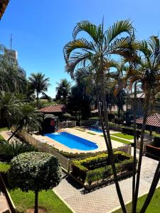 uitzicht op een zwembad met palmbomen bij Fênix Plaza Hotel in Aquidauana