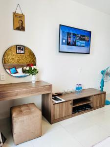 ein Wohnzimmer mit einem Tisch und einem TV in der Unterkunft DALAT STREAM HOTEL-Khách sạn đẹp Đà Lạt in Da Lat