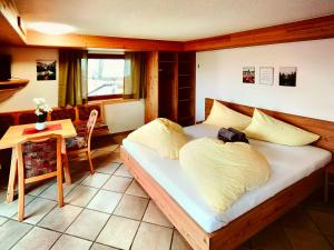 a bedroom with a bed and a table and a chair at Apartments Pitztaler Nachtigall in Arzl im Pitztal