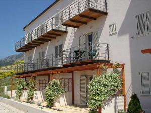 un grand bâtiment blanc avec un balcon et des plantes dans l'établissement Villa Lara Apartments, à Bol