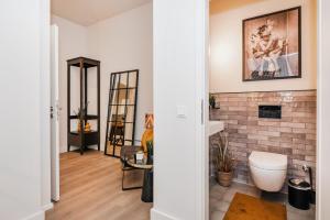 a bathroom with a toilet and a brick wall at S331 - Luxurious two bedroom duplex apartment in cologne in Cologne