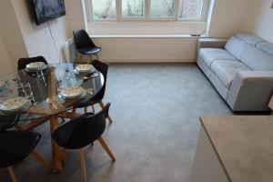 a living room with a couch and a table and chairs at TOK TOK S2 - Appartement 1Ch Plein cœur de Seclin in Seclin +4 photos