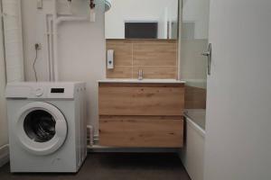 uma cozinha com uma máquina de lavar roupa e um lavatório em N°2 Seclin - Appartement plein cœur - 1 chambre em Seclin