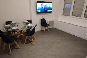 a dining room with a table and chairs and a television at TOK TOK S2 - Appartement 1Ch Plein cœur de Seclin in Seclin +3 photos