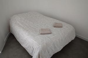 a bed with two towels on it in a room at N°2 Seclin - Appartement plein cœur - 1 chambre in Seclin