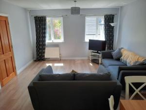 a living room with two couches and a table at Cushendall Cottage, Moneyvart in Cushendall