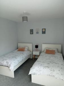 a bedroom with two beds and a table at Cushendall Cottage, Moneyvart in Cushendall