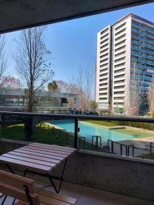 a balcony with a bench and a large building at GALA Dptos. Temp. Condominios del Alto in Rosario